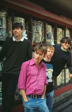 four young men standing in front of a store