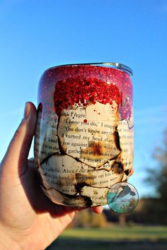 a person holding up a jar with writing on it in front of a blue sky