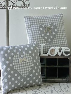 two decorative pillows sitting on top of a bed