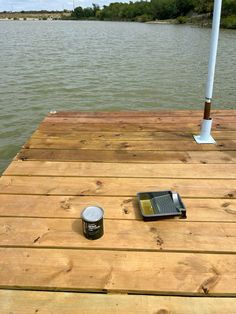 a can of paint sitting on top of a wooden dock