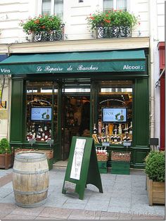 an outside view of a store with flowers in the window