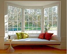 a white couch sitting under a window in a living room