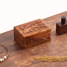 a small wooden box sitting on top of a table next to a string of beads