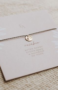 a personalized bracelet with a gold disc on it sitting on top of a card