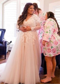 a woman in a wedding dress standing next to another woman