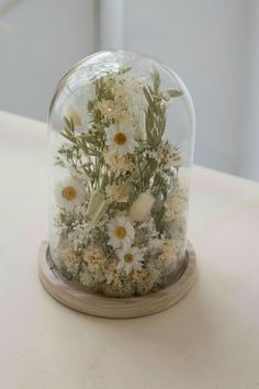 a snow globe with flowers in it sitting on a table