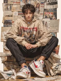 a young man sitting on top of stacks of newspapers