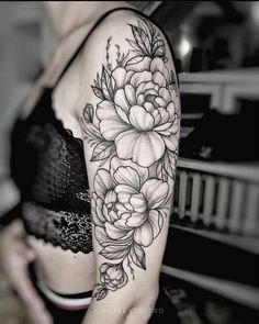 a woman's arm with flowers and leaves tattooed on the side of her body