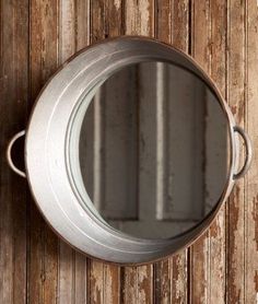 a round mirror mounted to the side of a wooden wall