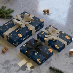 three presents wrapped in blue and gold paper with bows