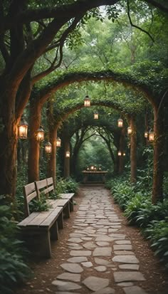 a stone pathway with benches and lanterns hanging from the trees overhanging it is surrounded by greenery