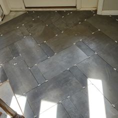 a tile floor that has been cleaned and is in the process of being installed with metal grouting