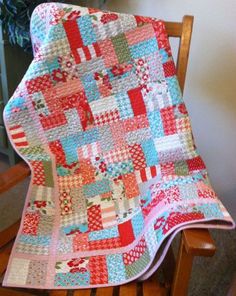 a red and blue quilt on a wooden chair