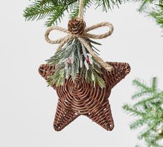 a wicker star ornament hanging from a christmas tree