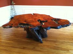 a large wooden table sitting on top of a hard wood floor next to a red wall