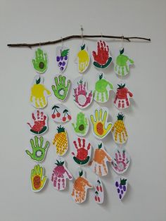 a bunch of handprints are hanging on a sticker board with clothes pins