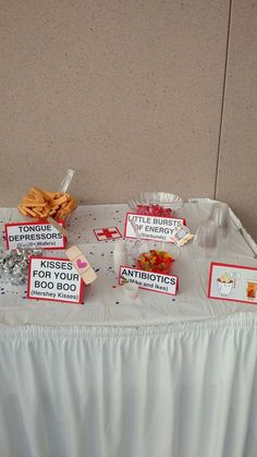 a table topped with lots of food next to a white wall and a sign that says kiss for your boo