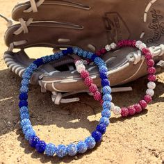 two baseball bracelets sitting on the ground next to a catcher's mitt