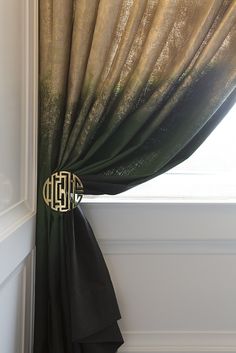 the curtain is open in front of a window with gold and green curtains on it