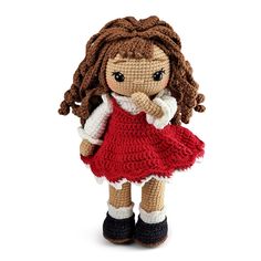 a crocheted doll is wearing a red dress and black boots, with her hand on her chin