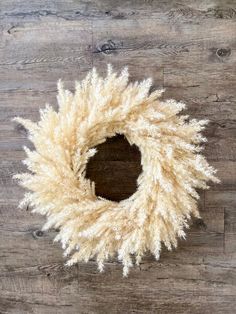 a white wreath on top of a wooden floor