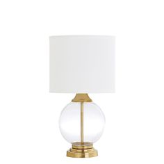 a lamp with a white shade on top of it and a gold frame around the base