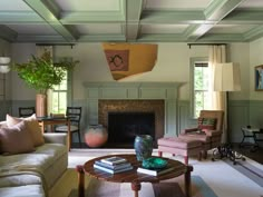 a living room filled with furniture and a fire place in the middle of a room