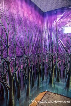 a room with purple walls and trees painted on it