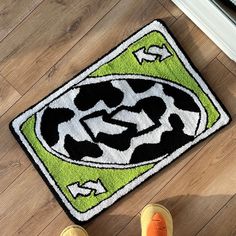 someone is standing on the floor in front of a rug with an image of a cow