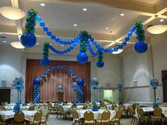 a banquet hall decorated with blue and green balloons