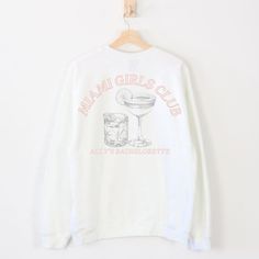 a white sweatshirt with the words miami girls club on it and a cocktail glass next to it