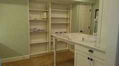 an empty bathroom with white cabinets and marble counter top, along with beige carpeted flooring