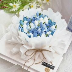 a bouquet of blue and white flowers sitting on top of a table