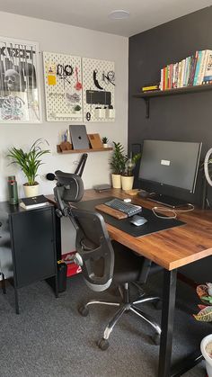 a desk with a computer on top of it in front of a bookshelf