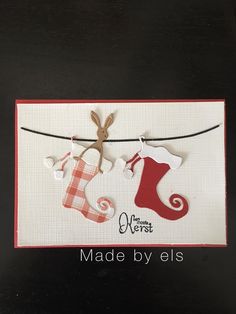 a christmas card with stockings hanging from a line