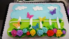 a birthday cake decorated with flowers and butterflies