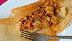 a white plate topped with food next to a fork