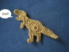 a crocheted toy dinosaur with a speech bubble above it that says rawr