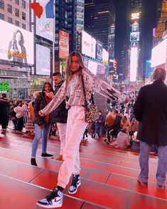 a woman standing on top of a red floor in the middle of a city at night