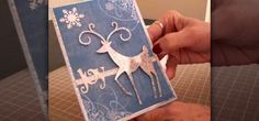 someone is holding up a card that looks like a reindeer with snowflakes on it