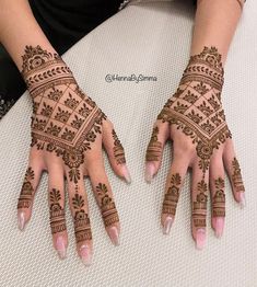 two hands with henna tattoos on them