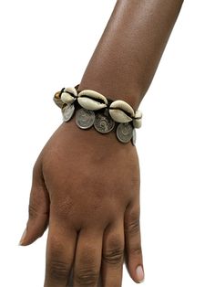 Expertly handcrafted, this Cowry Shell and vintage coin bracelet boasts a secure button fastening. Enjoy its unique blend of traditional and modern elements, perfect for adding a touch of sophistication to any outfit. Handmade with care, each piece is truly one-of-a-kind. Beach Goddess, Bracelet Measurements, Cowry Shell, Coin Bracelet, Modern Elements, Ear Climbers, Simple Bracelets, Shell Bracelet, A Bracelet