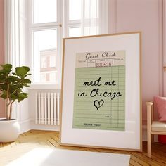 a framed poster with the words meet me in chicago next to a potted plant