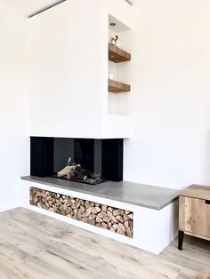 a white fireplace with wood stacked on top