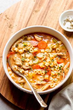 a bowl filled with pasta and vegetables next to a spoon