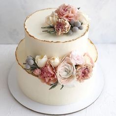 two tiered wedding cake with flowers on top