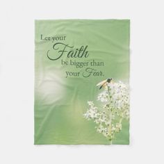 a green towel with white flowers and a bee on it that says, let your faith be bigger than your fear