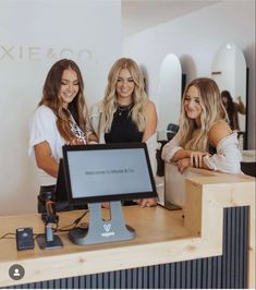 three beautiful women standing in front of a computer