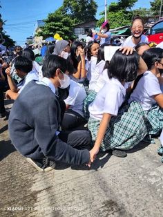 a group of people sitting on the side of a road next to eachother