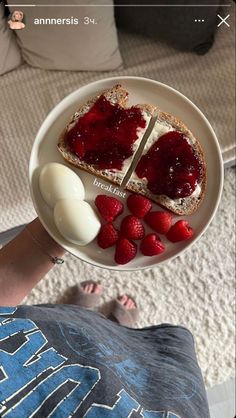 someone holding a plate with toast and berries on it